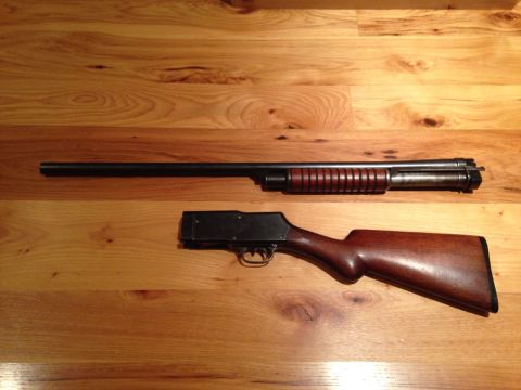 1996 Ford Bronco - Disassembled shotgun barrel and wooden stock laid out on a wood grain surface.