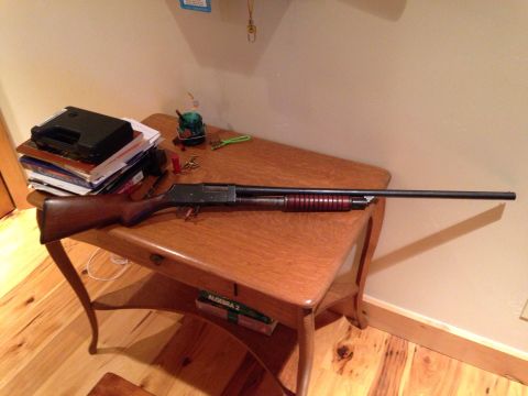 1996 Ford Bronco - A shotgun is displayed on a table next to books and other items.
