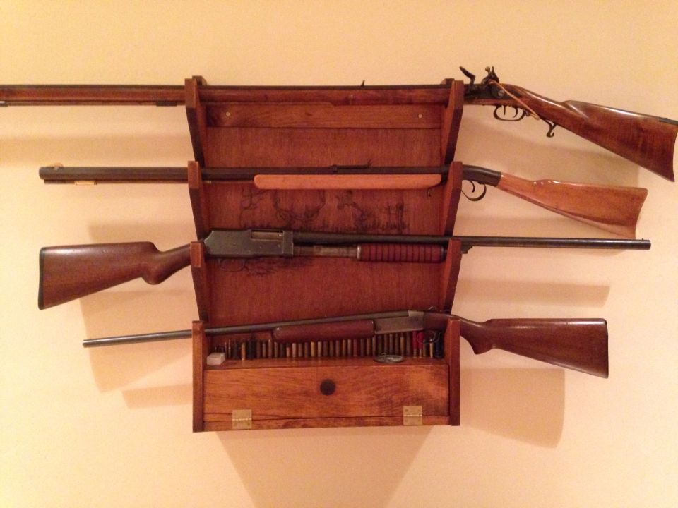 Wooden gun rack displaying several rifles and shotguns