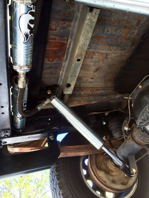 1977 Ford F-350 - Close-up of aftermarket suspension components, including a Fox shock absorber and a steering stabilizer.