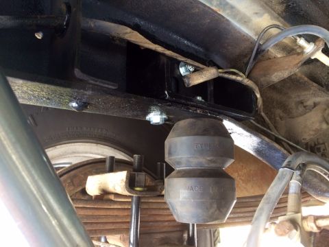 1977 Ford F-350 - Close-up view of the rear suspension system, showing a rubber bump stop and leaf springs.