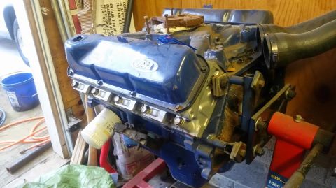 1979 Ford F-150 - Engine on stand, likely a Ford V8, with blue valve covers and an oil filter.