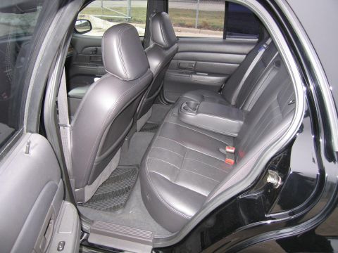 1985 Ford Crown Victoria LTD - Interior view of the rear seats and door panel of a black sedan.