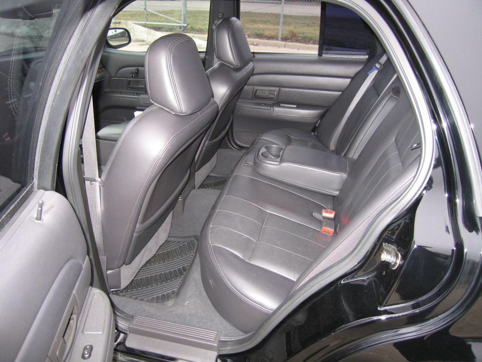 Black leather rear seats and interior of a 2005 Ford Crown Victoria LX Sport, viewed from the passenger side rear door