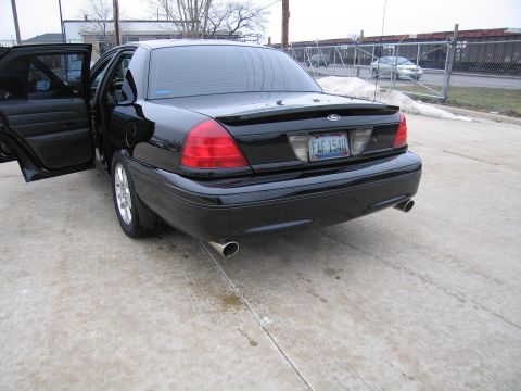 1985 Ford Crown Victoria LTD - Rear view of a black Ford Crown Victoria, showing its taillights, spoiler, and license plate FAF 1540.