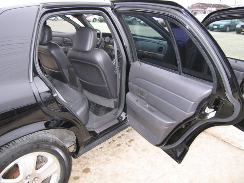 1985 Ford LTD Crown Victoria - Interior view of a black sedan, revealing its leather seats and door panels with the doors ajar.