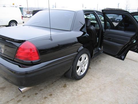 1985 Ford LTD Crown Victoria - This black sedan is shown from the rear with its doors open, revealing the interior.