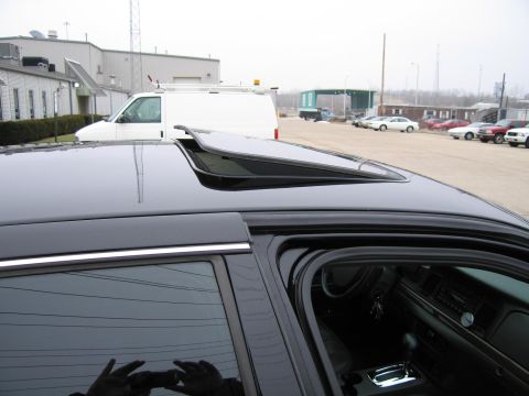 1985 Ford LTD Crown Victoria - Interior view of a black car, showing the dashboard and an open sunroof.