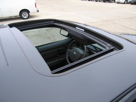 1985 Ford LTD Crown Victoria - Interior view of a Ford Crown Victoria, showing the open sunroof and steering wheel.