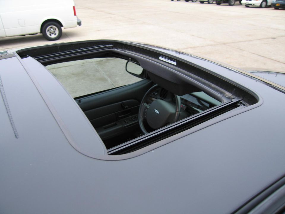 Interior view of a Ford Crown Victoria with sunroof open, showing steering wheel and dashboard
