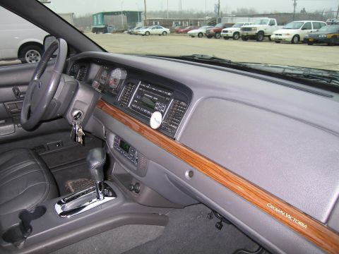 1985 Ford LTD Crown Victoria - The interior of a Ford Crown Victoria, wood grain trim and a prominent gear shifter.