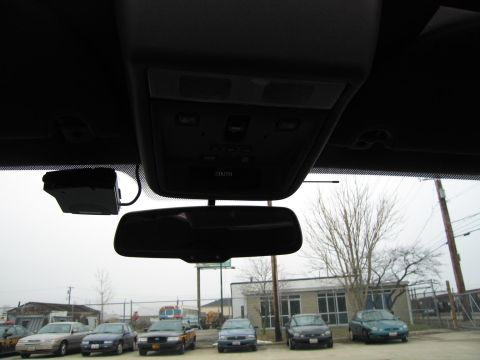 1985 Ford LTD Crown Victoria - Interior view of a vehicle's rearview mirror and overhead console, with several cars parked outside.