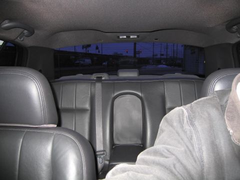 1985 Ford LTD Crown Victoria - Interior view of a car's back seat, with a view of the outside through the rear window.