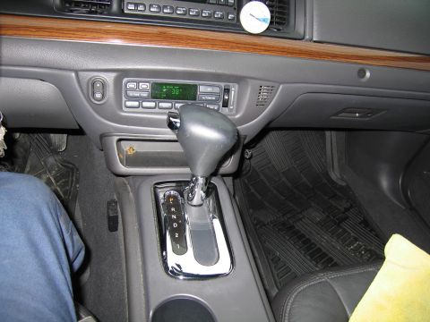 1985 Ford LTD Crown Victoria - The interior of a car shows the gear shifter, climate controls, and radio display.