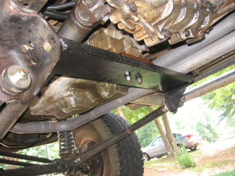 1988 Ford Bronco - Undercarriage view shows the transmission and driveshaft of a vehicle, with another car visible in the background.