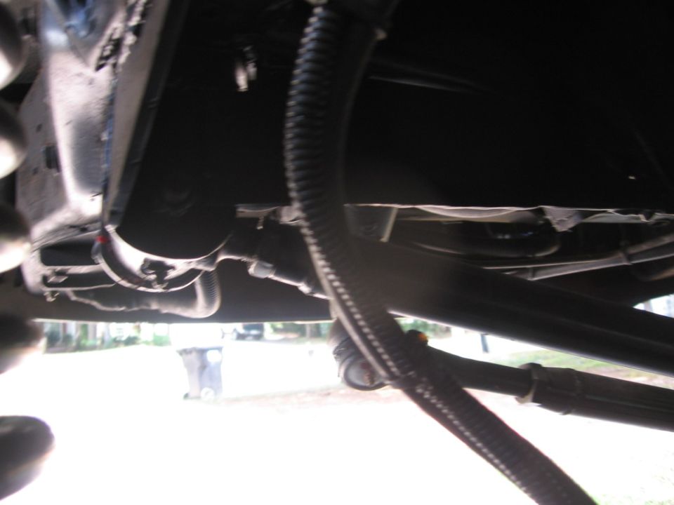Underside view of vehicle frame and hoses. Supermotors.net logo visible