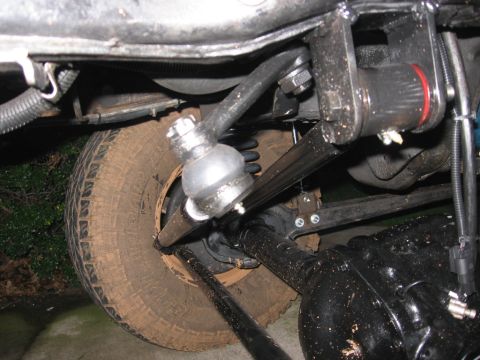 1988 Ford Bronco - Close-up view of the vehicle's undercarriage, focusing on the suspension and tire assembly.