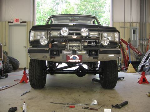 1988 Ford Bronco - Modified Ford Bronco front end with winch and auxiliary lights, lifted suspension visible.