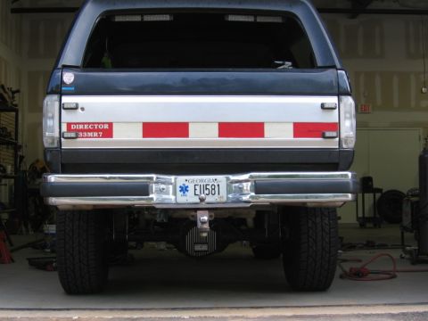 1988 Ford Bronco - The rear of a dark blue SUV is shown, a silver tailgate insert with red and white stripes and a Georgia license plate.