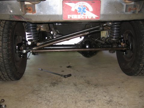 1988 Ford Bronco - Close-up view of the undercarriage, focusing on the steering and suspension system of a vehicle.