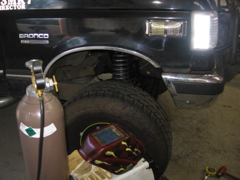 1988 Ford Bronco - A black 1988 Ford Bronco is partially visible next to welding equipment.