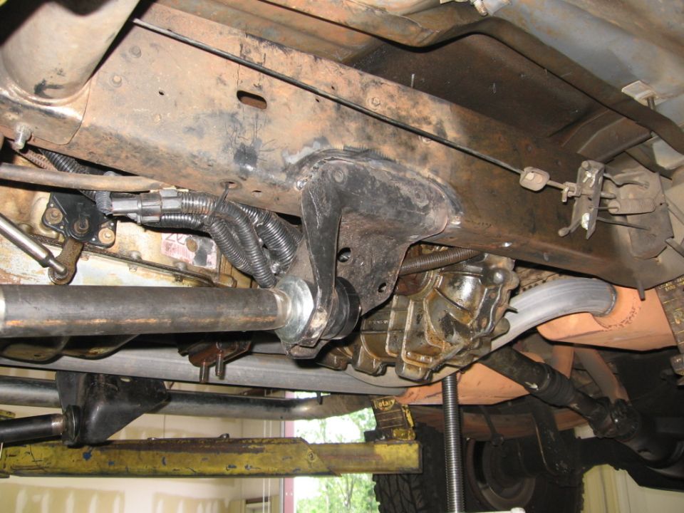 Undercarriage of a vehicle with visible suspension components, exhaust, and drivetrain parts