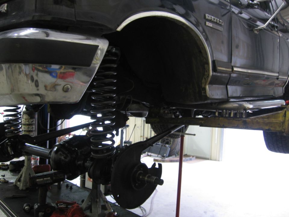 Side view of a lifted 1988 Ford Bronco's suspension with heavy-duty springs and shocks