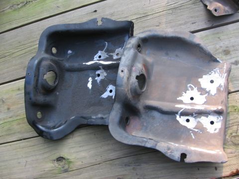 1988 Ford Bronco - Two metal brackets, possibly for a vehicle, are shown on a wooden deck. One bracket is darker than the other.