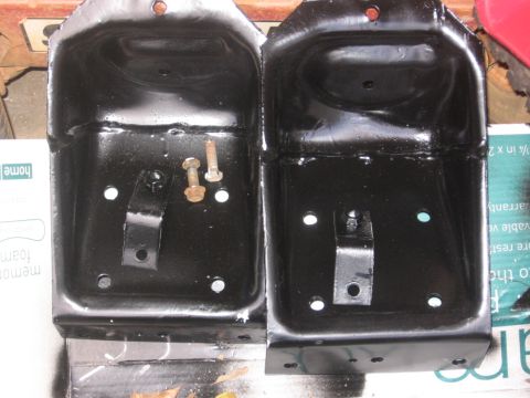 1988 Ford Bronco - Two freshly painted metal brackets are displayed, one with hardware still attached.