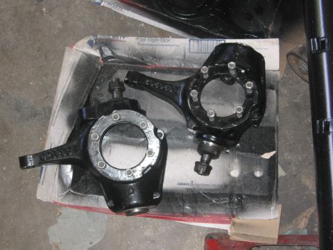 1988 Ford Bronco - Two black steering knuckles are shown resting on a cardboard box.