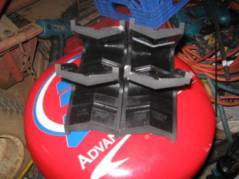 1988 Ford Bronco - Four black rubber jack stands are arranged on a red surface with visible text and graphics.
