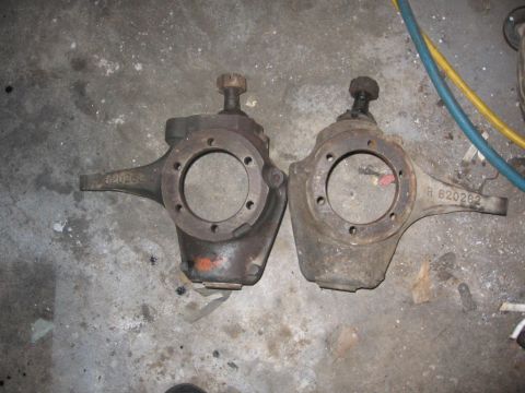 1988 Ford Bronco - Two vehicle steering knuckles are shown side-by-side on a workshop floor, with visible part numbers.