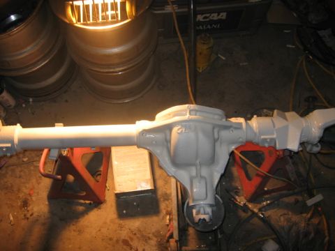 1988 Ford Bronco - Gray painted differential axle assembly resting on jack stands in a garage setting.
