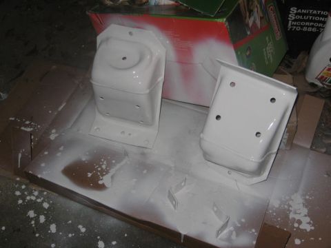 1988 Ford Bronco - Two white painted metal brackets are shown on a cardboard surface with overspray.