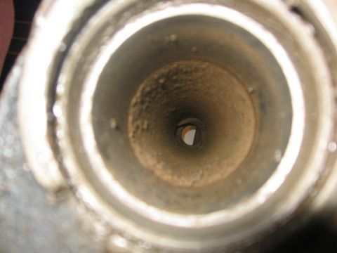 1988 Ford Bronco - Close-up view inside a corroded exhaust pipe, showing the internal passage and a small hole at the far end.