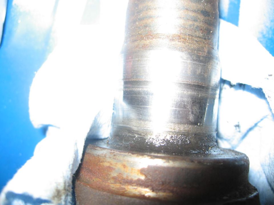 Close-up of a worn metal shaft with SuperMotors.net watermark