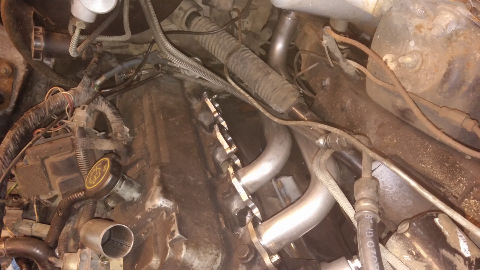 Engine bay showing custom exhaust headers and wiring harnesses