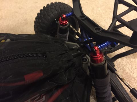 2014 Dodge 1500 - Close-up view of the suspension system on a remote control car, showing red and blue shock absorbers.