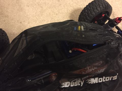 2014 Dodge 1500 - A black mesh bag with an open zipper shows internal components of a remote control car, including a red wire and battery pack.