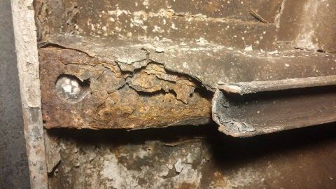1979 Ford Bronco - This close-up shows significant rust and deterioration on a vehicle's metal frame component.