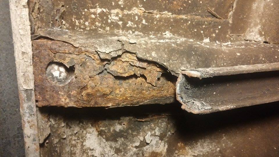 Close-up of heavily rusted metal frame with a bolt visible