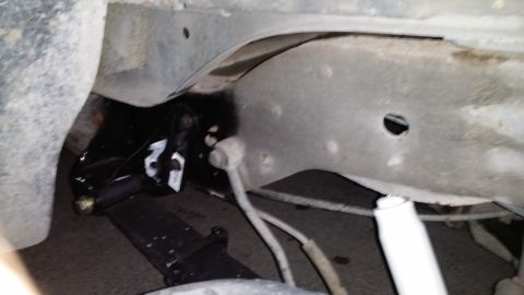 1996 Ford Bronco - Underside view of a vehicle's suspension system, showing leaf springs and a shock absorber.