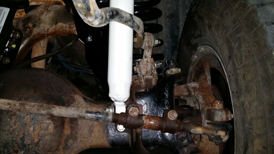Close-up of rusty suspension parts and tire tread