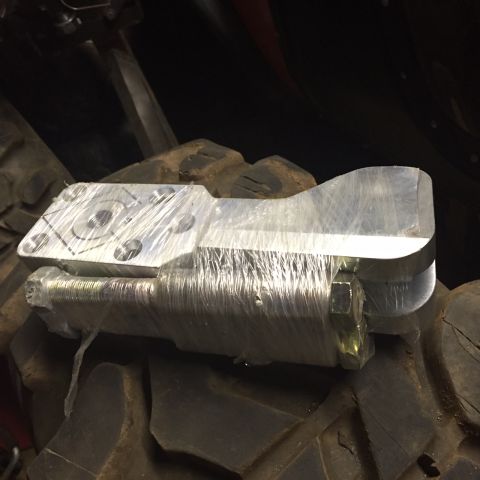 1994 Ford Bronco - An aluminum axle part, wrapped in plastic, is shown resting on a large tire.