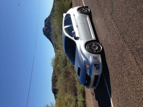 2005 Audi S4 - White sedan with a dark hood and aftermarket wheels parked on a paved road.