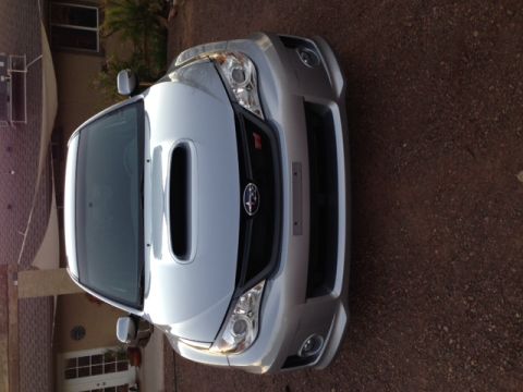 2005 Audi S4 - A silver Subaru WRX STI is parked in a driveway, displaying its distinctive front grille and hood scoop.