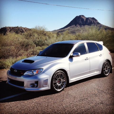 2005 Audi S4 - Silver Subaru WRX hatchback parked on a desert road with a mountain behind it.