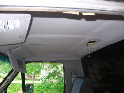 1988 Ford Bronco - Interior view of the vehicle's ceiling, including sun visors and some exposed wiring.