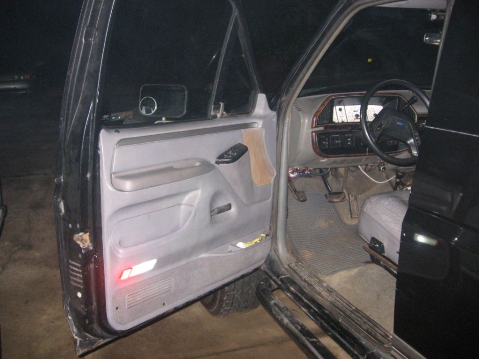 Interior shot of a truck's driver side door open, showing the dashboard, steering wheel, and door panel