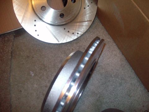 2004 Ford Crown Victoria - Two drilled and slotted brake rotors are shown, one stacked on top of the other.